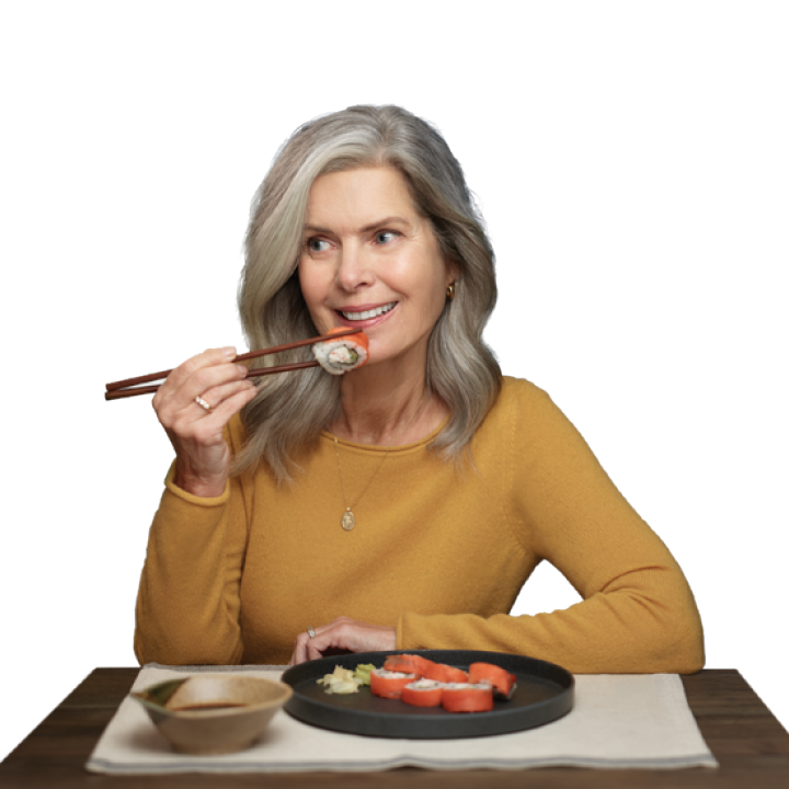 older well to do woman enjoying sushi takeout at home